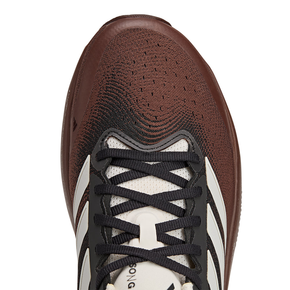 Close-up of adidas SFTM Supernova Rise 3 running shoes in auburn color, showing the textured upper and sleek design.