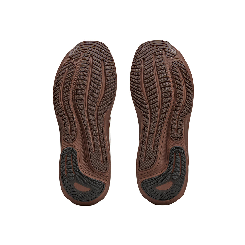 A pair of adidas SFTM Supernova Rise 3 running shoes in auburn, shown from the bottom view, highlighting the shoe sole and design details.
